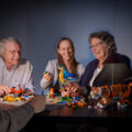 Vier Personen bauen mit LEGO Steinen und Modellen