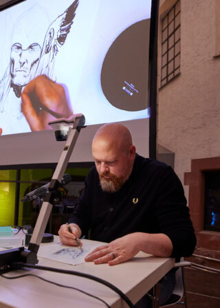 Nic Klein beim Zeichnen der Marvel-Figur Thor während eines Live-Talks im Rahmen der Sonderausstellung "Superheroes".