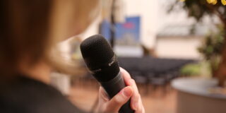 Vortragende mit Mikrofon im Innenhof des Museums.