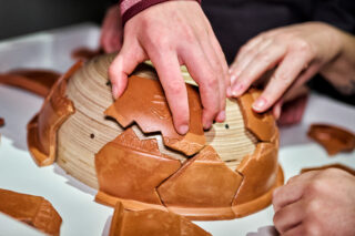 Besucherinnen beim Zusammensetzen eines Terra Sigillata-Puzzles.