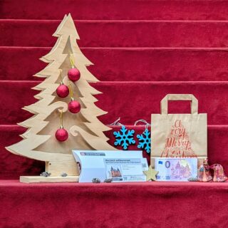 Weihnachtspaket: Null-Euro-Schein mit dem Bild des Museums, Wertgutschein über 20 Euro, Geschenktüte und weihnachtliche Dekoration.