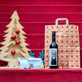 Weihnachtspaket: Riesling aus dem Weingut Anselmann, Generationenkarte für die Sammlungsausstellung "Kreuz und Krone", Geschenktüte und weihnachtliche Dekoration.