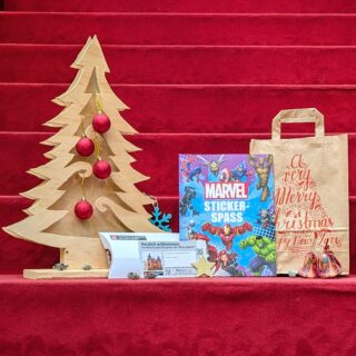 Weihnachtspaket: Stickeralbum mit Marvel Superhelden, Generationenkarte für die Sonderausstellung "Superheroes", Geschenktüte und weihnachtliche Dekoration.