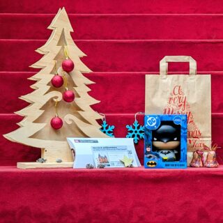 Weihnachtspaket: Spardose "Batman", Generationenkarte für die Sonderausstellung "Superheroes", Geschenktüte und weihnachtliche Dekoration.