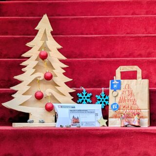 Weihnachtspaket: Schlüsselanhänger des KSC, Generationenkarte für die Sonderausstellung "Fußballfieber", Geschenktüte und weihnachtliche Dekoration.