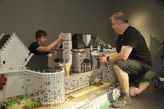 Martin Schild, Vorsitzender des Vereins Lauter Steine e.V. aus Kaiserslautern, und sein Sohn Henrik während des Aufbaus des LEGO Modells der Burg Nanstein.