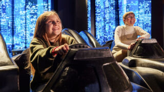 Zwei Besucherinnen in Batmobilen.