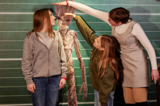 Besucherinnen im Größenvergleich mit der Marvel-Figur Groot.