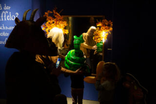 Verkleidungsstation in der Ausstellung "Der Grüffelo kommt zurück" Besucherinnen und Besucher an einer Verkleidungsstation in der Ausstellung "Der Grüffelo kommt zurück".