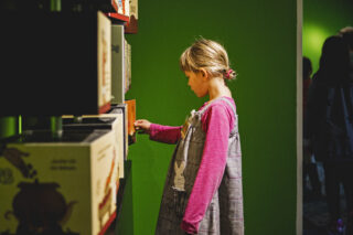 Besucherin in "Robin Hood" Junge Besucherin an einer Mitmachstation in der Ausstellung "Robin Hood".